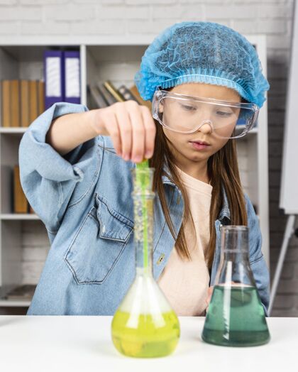 调查戴着安全眼镜做科学实验的女孩化学儿童安全