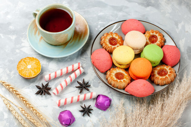 生的半顶视图一杯茶配饼干和法式马卡龙 表面浅白色糖果甜甜的糖蛋糕烤饼干咖啡糖果饮料