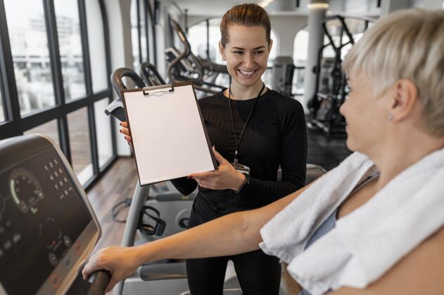 锻炼训练计划培训师和客户展示剪贴板教练健康运动