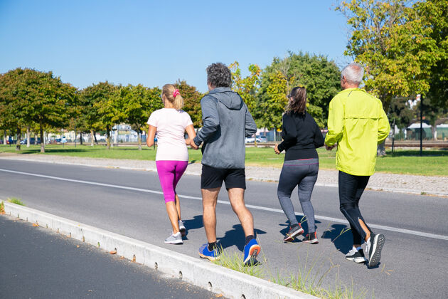 社区一群穿着运动服的成熟慢跑者在户外跑步 参加马拉松训练 享受晨练全程射击退休人士和积极的生活方式理念公园成人跑步者