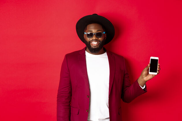 胡须帅气时尚的黑人男子展示手机屏幕手机智能手机显示