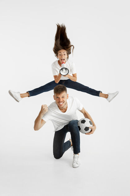 情侣美丽的年轻夫妇的肖像足球或足球迷面部表情 人类情感 广告 体育概念女人和男人跳跃 尖叫 玩得开心快乐女性年轻