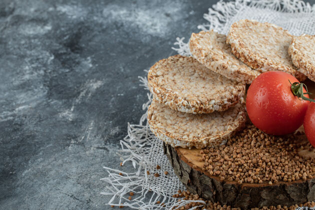 健康酥皮面包 西红柿和生荞麦放在大理石表面生的新鲜脆的面包