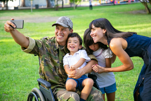 母亲快乐的残疾军人和他的妻子和两个孩子在公园里自拍老兵的战争或休闲时间与家庭观念女人摆姿势制服