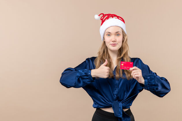 举行正面图年轻女性手持红色银行卡上粉色背景钱假日照片新年圣诞节情感自由的地方年轻微笑人
