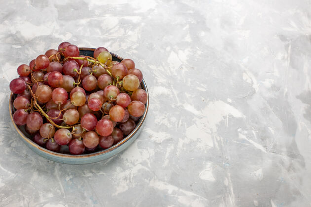 水果正面是新鲜的红葡萄 多汁 醇厚 甜的水果 浅白的桌子上有水果 新鲜 醇厚的果汁酒水果可食用水果视野