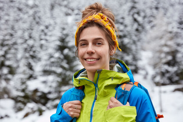 满意快乐的游客在雪山顶上摆姿势 享受冬日徒步旅行 头戴黄色头带 穿着休闲夹克外观风景乐观