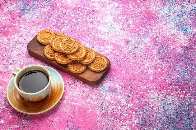 饼干半俯视圆甜饼干美味的小饼干与茶内衬在粉红色的办公桌上棕色圆形美味