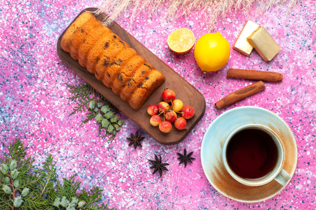 面团俯瞰美味的蛋糕 甜甜可口 樱桃 肉桂和一杯茶放在粉红色的桌子上食物肉桂糖