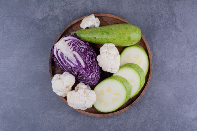 水果把西葫芦片 紫白菜和花椰菜放在木盘上切碎托盘美味