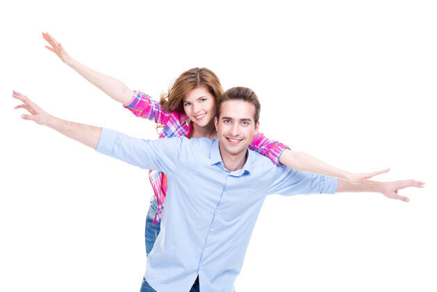 男性一对微笑的夫妇举起双手站着的肖像养育快乐拥抱