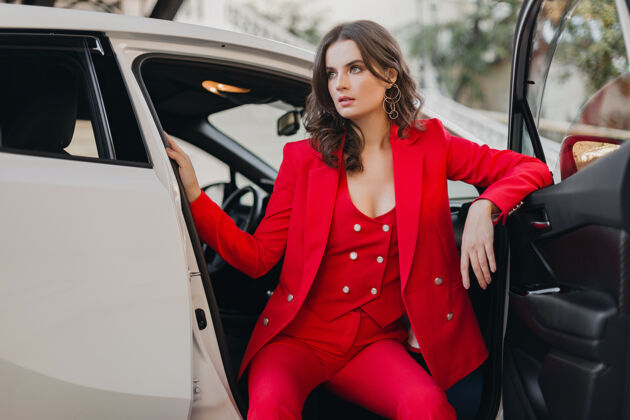 女人穿着红西装的性感富商美女在白色汽车里摆姿势女性女人车