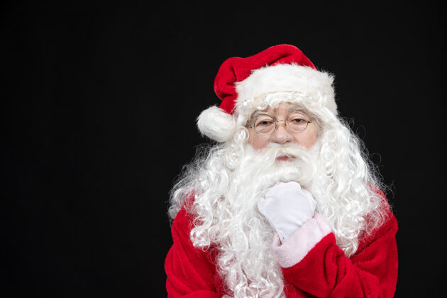 圣诞老人圣诞老人穿着经典的红色套装 黑墙上留着白胡子的正面图圣诞老人服装高级