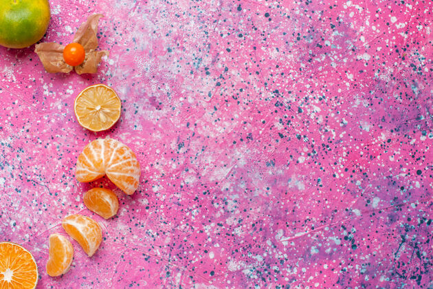 新鲜在浅粉色的桌子上俯瞰新鲜酸橘子和柠檬粉红色花瓣橘子