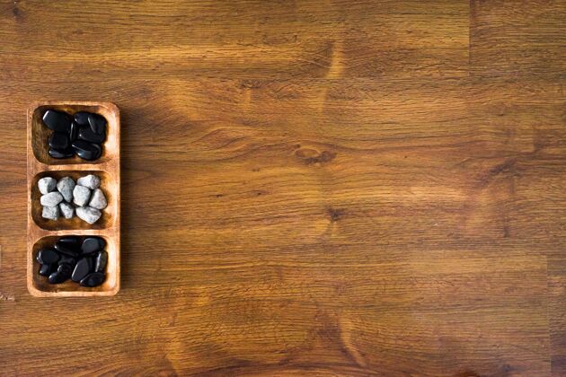 硬的高角度拍摄的白色和黑色的岩石在一个木制板上的木制表面地质木头自然