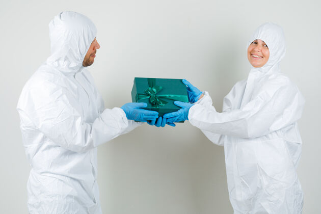 女人两个医生穿着防护服互相赠送礼品盒护理现代医学