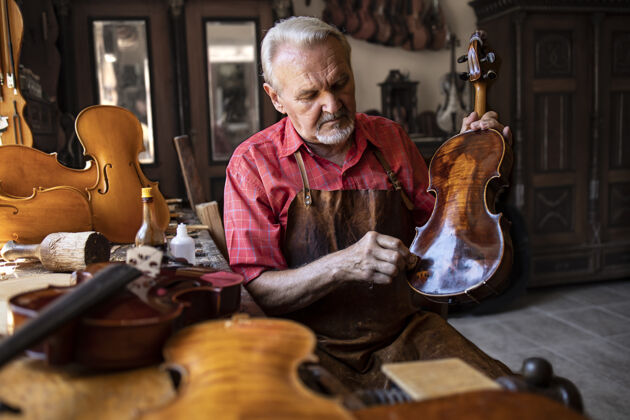 手工高级木匠在他的木匠工作室里打磨小提琴乐器锯屑正品小提琴