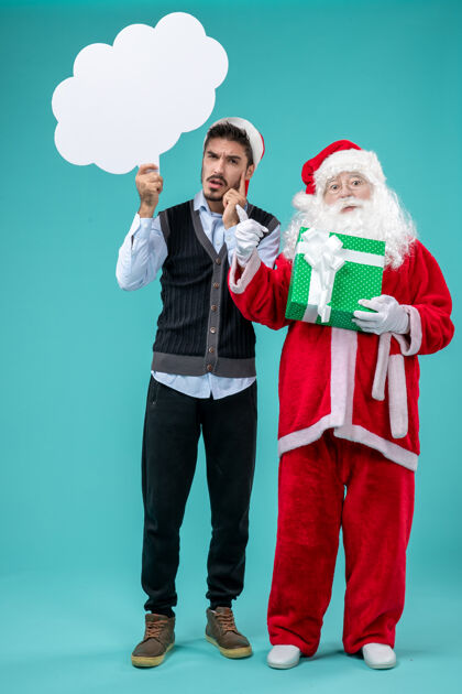 圣诞老人前视图圣诞老人与年轻男子谁持有白云标志蓝色地板圣诞新年假期雪圣诞老人圣诞圣诞老人