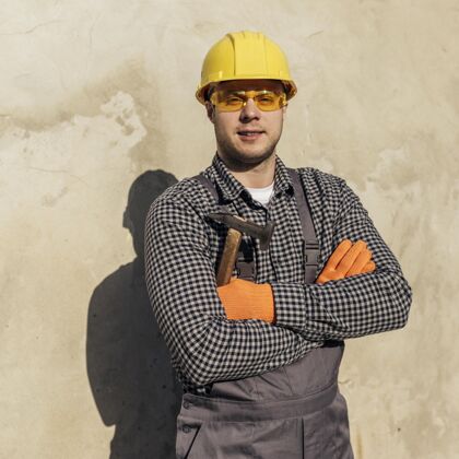 安全帽戴防护眼镜和安全帽的工人的前视图工作工作方形