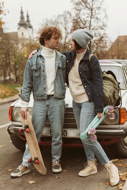 青年女人和男人拿着他们的滑板现代人休闲