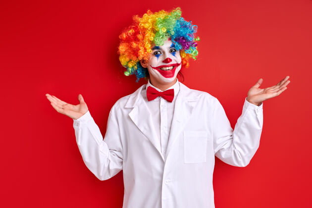 幽默丑角表演 小丑面带笑容 身穿白色服装 在红色背景上画脸举行服装