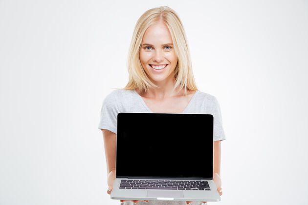 笔记本电脑一个微笑的金发女人展示白色背景上的空白笔记本电脑屏幕白种人显示器空
