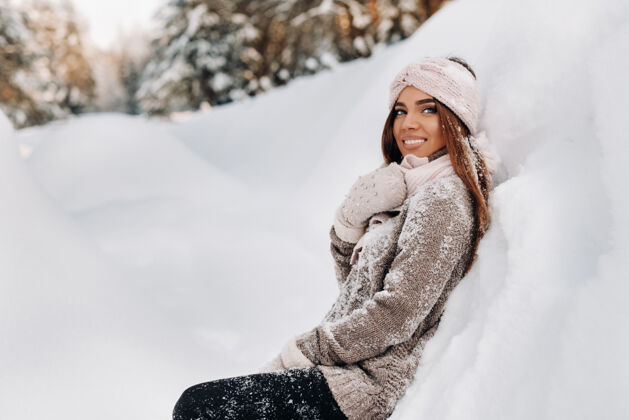 手套冬天 一个穿着毛衣和手套的女孩站在被雪覆盖的背景上寒冷温柔霜冻
