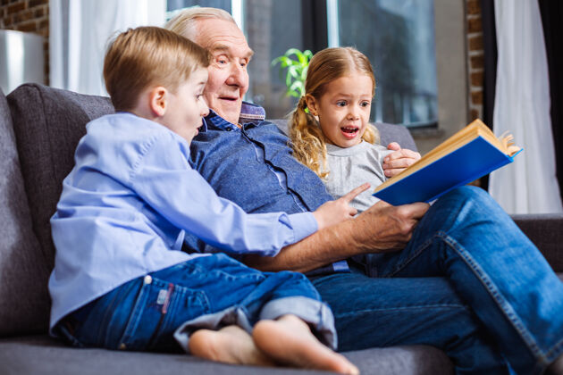成熟快乐的小兄弟姐妹们一边看书 一边和爷爷在沙发上休息孙女平板电脑房子