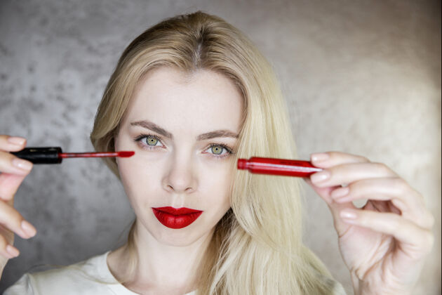 技术一位年轻女子的画像 她用鲜红的嘴唇化妆产品可爱艺术家