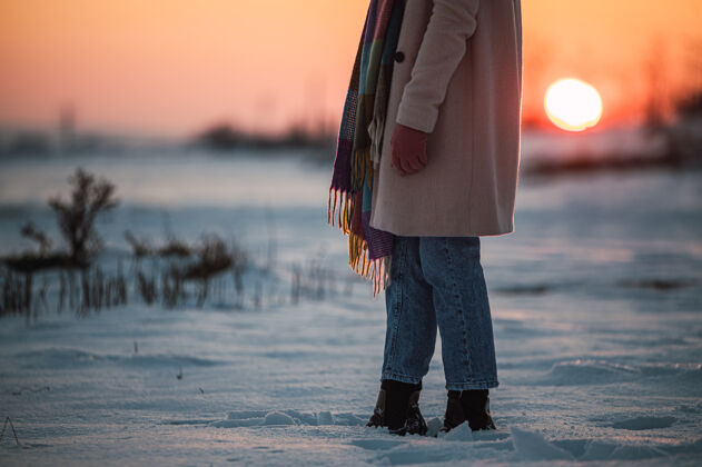 痕迹日落时分 在冬天的乡下 在新鲜的白雪上 收割着一个穿着暖和的衣服和靴子 面目全非的女人漫步环境活动