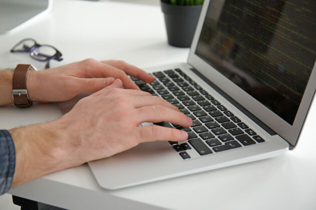 开发男性手放在笔记本电脑键盘上 特写桌子人显示器