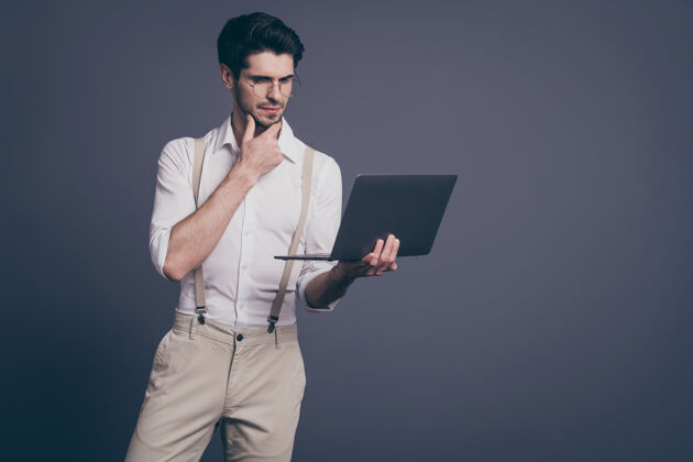 电脑头脑沉思的公司老板的肖像男人工作电脑思考决定困难的创业问题穿时髦的衣服眼镜企业家裤子