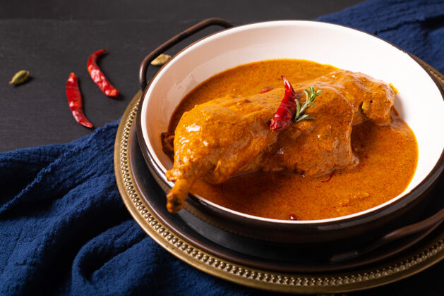 腿美食概念自制黑底提卡马萨拉鸡或红咖喱巴基斯坦晚餐背景