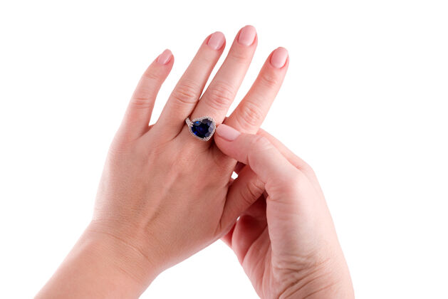 珠宝一个女人在尝试一个心形的蓝色蓝宝石戒指隔离在白色背景宝石明亮形状