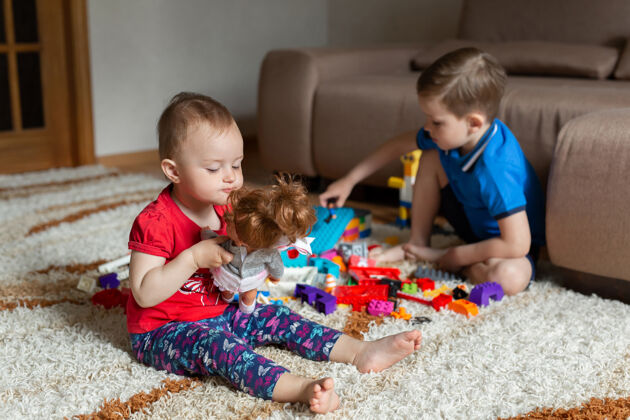 娃娃哥哥在地毯上玩建筑工具 我妹妹在玩洋娃娃公寓婴儿塑料