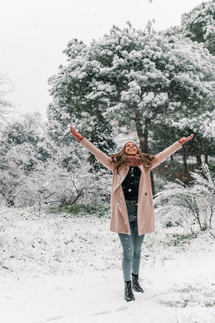 奇迹时尚的年轻女子穿着暖和的衣服 在冬天扔雪 享受周末享受仙境堆