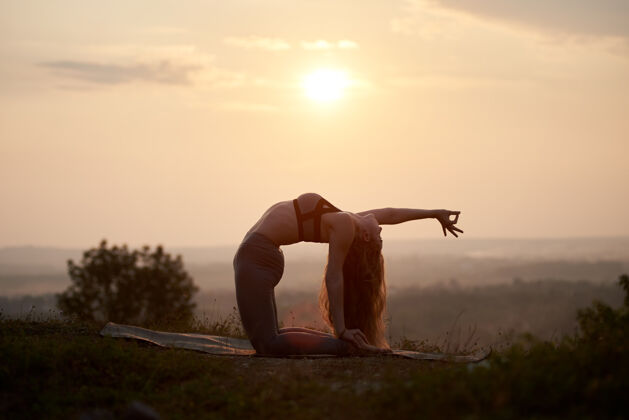瑜伽日落时分在户外练瑜伽的年轻女子日落女人困难