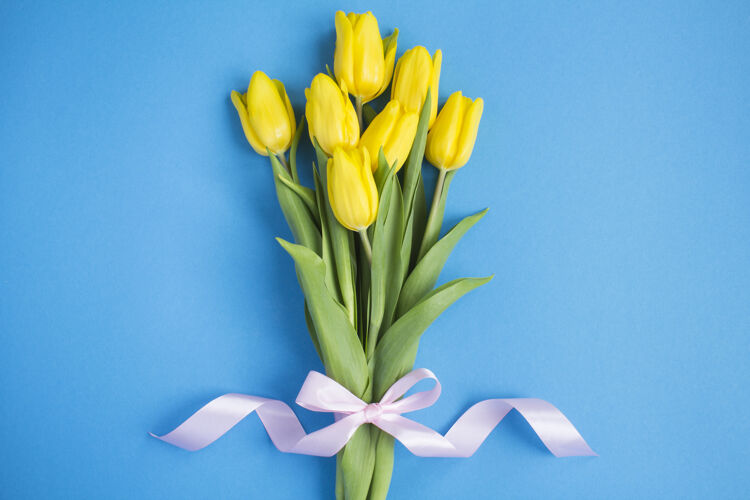 祝贺蓝色背景上的一束黄色郁金香春天郁金香花束