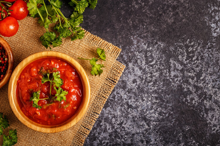 胡椒在一个木碗里放上大蒜和欧芹的番茄酱食谱厨房配料
