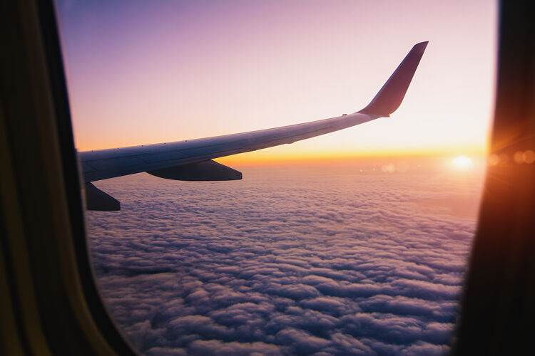 交通透过飞机的窗户看日出时发出闪光的机翼-图像飞机天空飞机