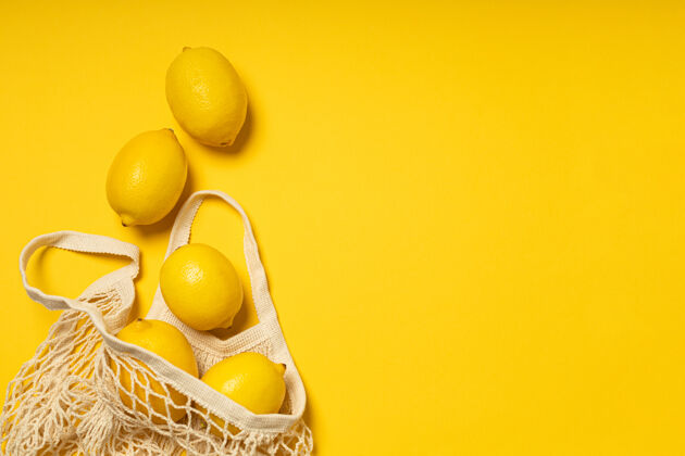 维生素环保袋 黄色背景上有成熟的黄色柠檬素食者团体颜色