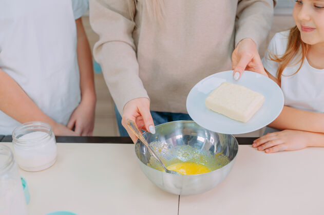 女人妈妈教女儿们在厨房做面团和打鸡蛋鸡蛋厨房年轻