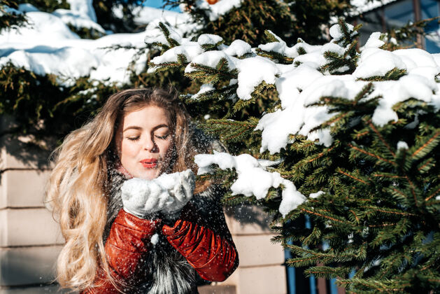 女孩情绪化的女孩在她手中吹雪季节人雪