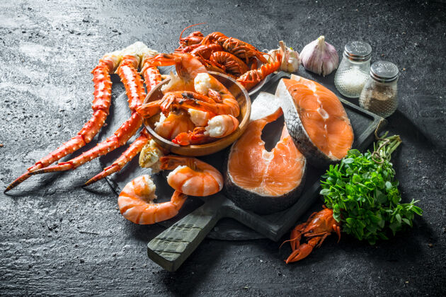 切片把新鲜的鱼排放在砧板上 配上煮熟的虾 小龙虾和螃蟹食物鱼健康