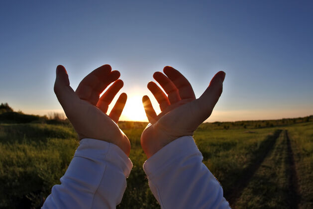 光在夕阳的余晖中举起双手行动光线精神