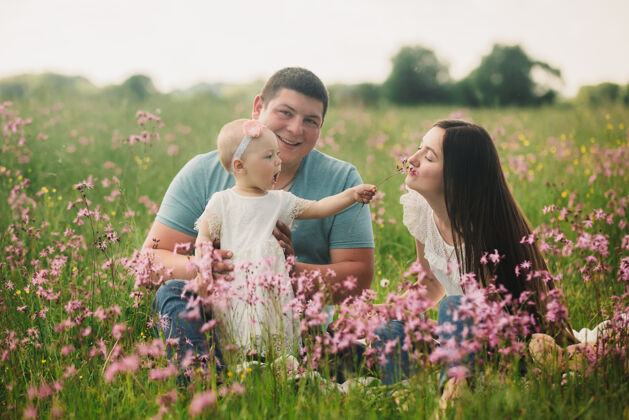 春天一家人一起在野花盛开的夏日田野里享受生活爱婴儿女人