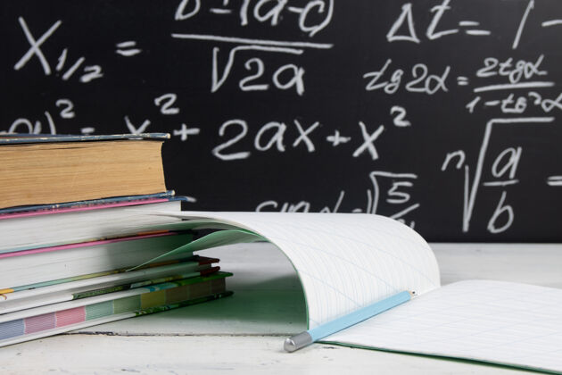 书黑板背景上有数学公式的书和笔记本铅笔学习黑板