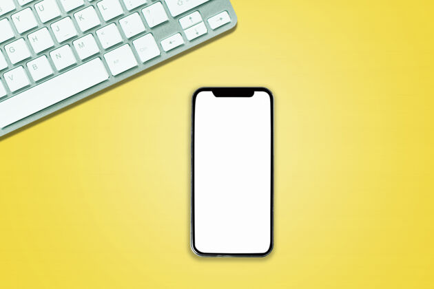 工作上图为手机电脑笔记本上方的办公风格白黄色背景办公室电话手机