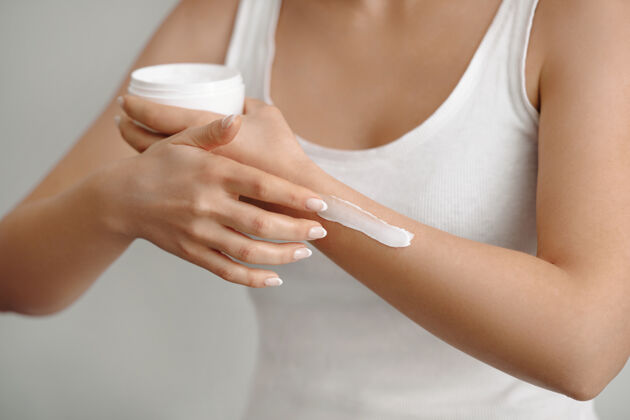皮肤漂亮女人的手奶油特写在手上涂防护霜的女人健康感官产品