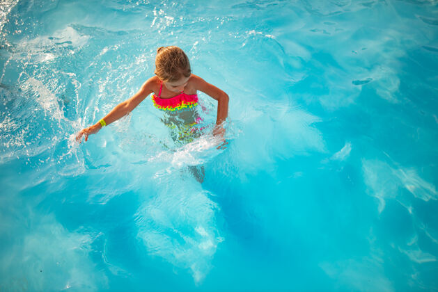 娱乐顶视图快乐的小女孩穿着鲜艳的泳装在清澈温暖的池水里游泳休闲清晰玩耍
